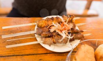 Fried shish kebab on sticks in a cafe .
