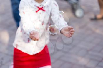 Girl playing with soap bubbles in the park