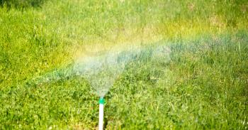 Rainbow from a water fountain in the nature .