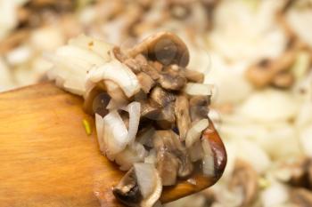 Mushrooms with onions are fried in a frying pan .