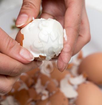 The girl is cleaning the egg with her hands .
