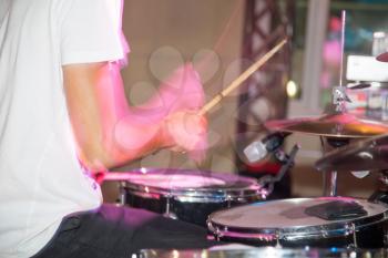 Musician plays drums in a rock band .