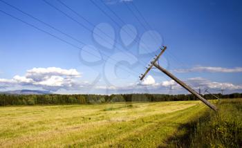 Royalty Free Photo of Falling Telegraph Poles on a Mown Field