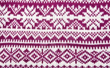 knitted colored background with a pattern in the shape of snowflakes