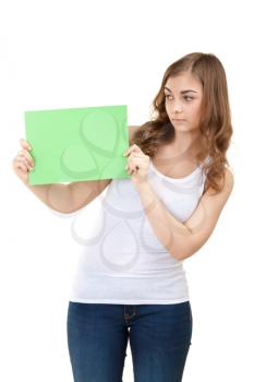 beautiful girl looking into a blank green sheet of paper. Isolate on white