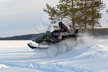 man riding a snowmobile on the lake