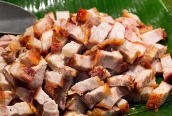 Roast pork cut into pieces on palm leaf in Thailand
