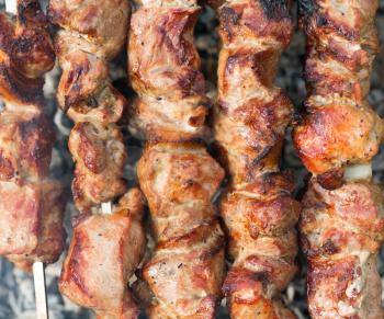 Background of shish kebab on skewers on the grill with coals