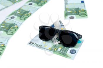 Banknotes of 100 euro and sunglasses isolate on white