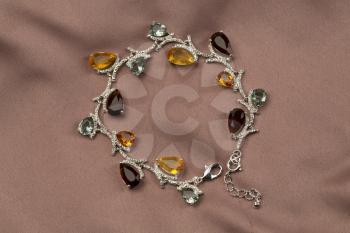 Precious bracelet with stones on a satin brown background