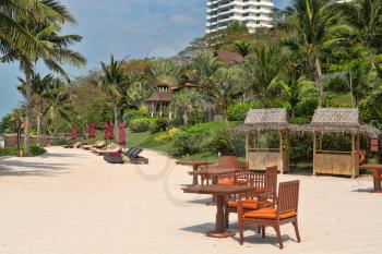 Sandy beach of a luxury hotel, sun beds, tables.