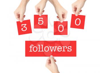 3500 followers written on cards held by hands