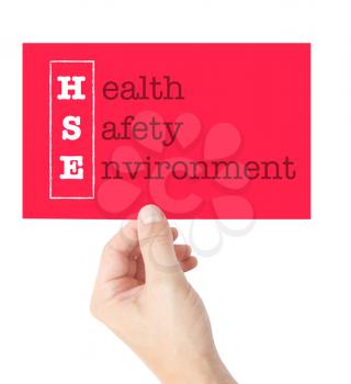 Health Safety Environment explained on a card held by a hand