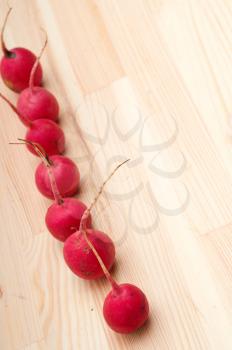 fresh red raw  raddish over pine wood table closeup