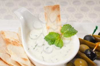fresh Greek Tzatziki yogurt dip and pita bread and pickels
