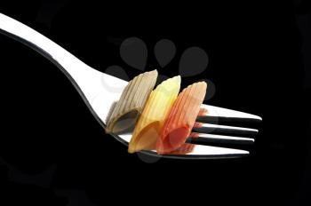 italian penne pasta on a fork on black background