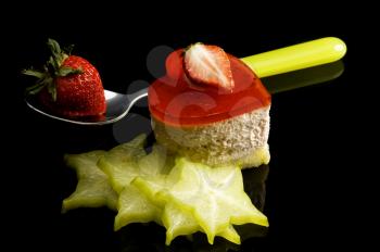 heart shaped strawberry cake with carambola or star fruit decoration over black background