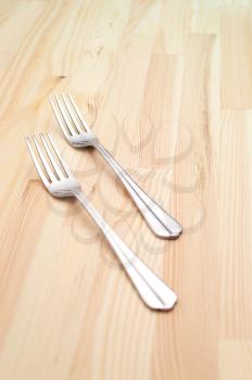 two fork on a kitchen pinewood table closeup