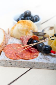 cold cut assortment cheese salami and fresh pears served on a granite stone