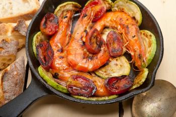 roasted shrimps on cast iron skillet  with zucchini and tomatoes