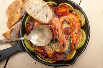 roasted shrimps on cast iron skillet  with zucchini and tomatoes