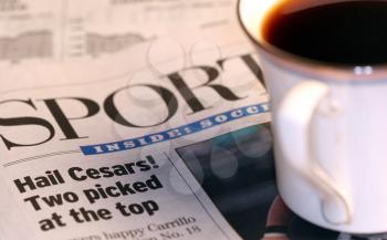 Royalty Free Photo of a Cup of Coffee on a Newspaper