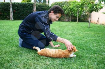 Royalty Free Photo of a Teenager Petting a Cat