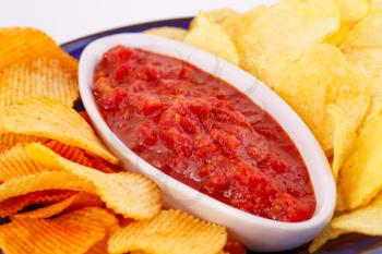Potato chips and red sauce closeup image.