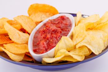 Potato chips and red sauce isolated on gray background.