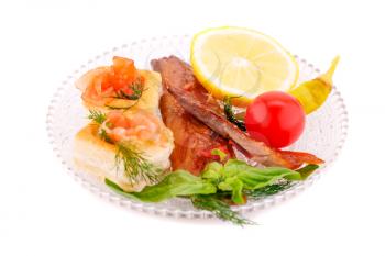 Smoked fish with fresh vegetables and lemon on plate isolated on white background.