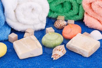 Colorful rolled towels with candles and shells closeup picture.
