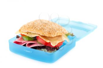 Sandwich with fresh vegetables, ham and cheese in plastic container isolated on white background.