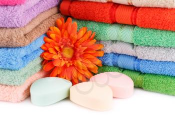 Colorful towels stacks, flower and soaps closeup picture.