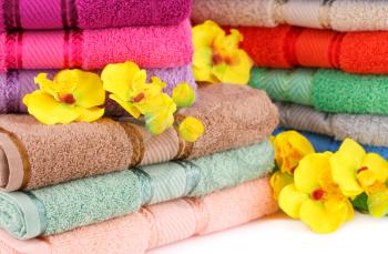 Colorful towels stacks with flowers closeup picture.
