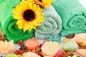 Spa set with towels, candles, flowers and various formed soaps closeup picture.