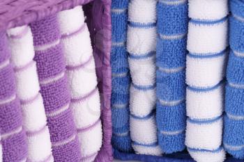 Pink, blue and white folded towels in boxes closeup picture.