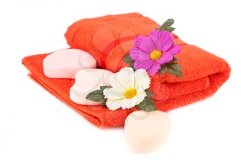 Folded towel, soaps and flower isolated on white background.