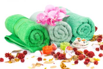 Spa set with towels, candles, flowers and stones closeup picture.