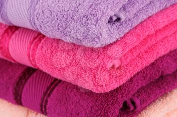 Colorful folded towels stack closeup picture.
