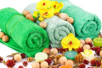 Spa set with towels, candles, wooden balls and flowers closeup picture.