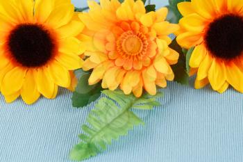 Yellow fabric flowers on cloth background, closeup picture.