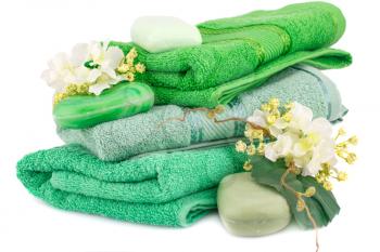 Folded towels, soaps and flowers isolated on white background.