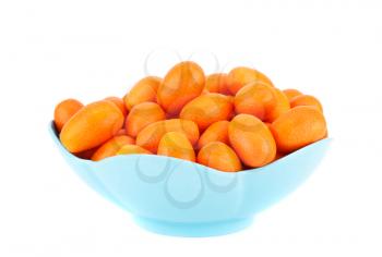Ripe kumquats in blue bowl isolated on white background.