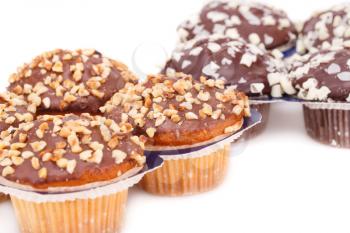 Muffins with chocolate and nuts on white background.
