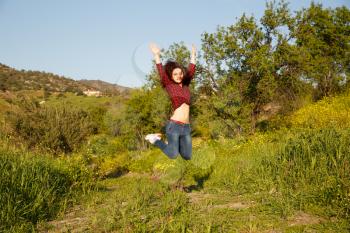 Young pretty woman jumping in garden.