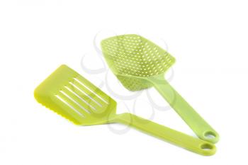 Green plastic kitchen utensils isolated on white background.