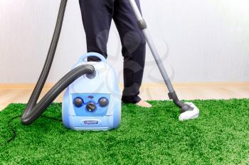 Vacuum cleaner in action  - a men cleaner a carpet. 