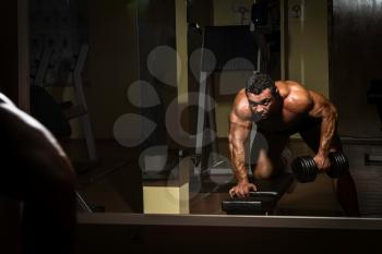 male bodybuilder doing heavy weight exercise for back