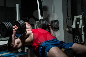 young bodybuilder doing bench press for chest