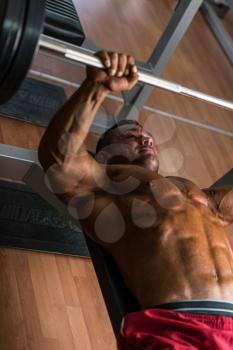 shirtless body builder doing bench press for chest